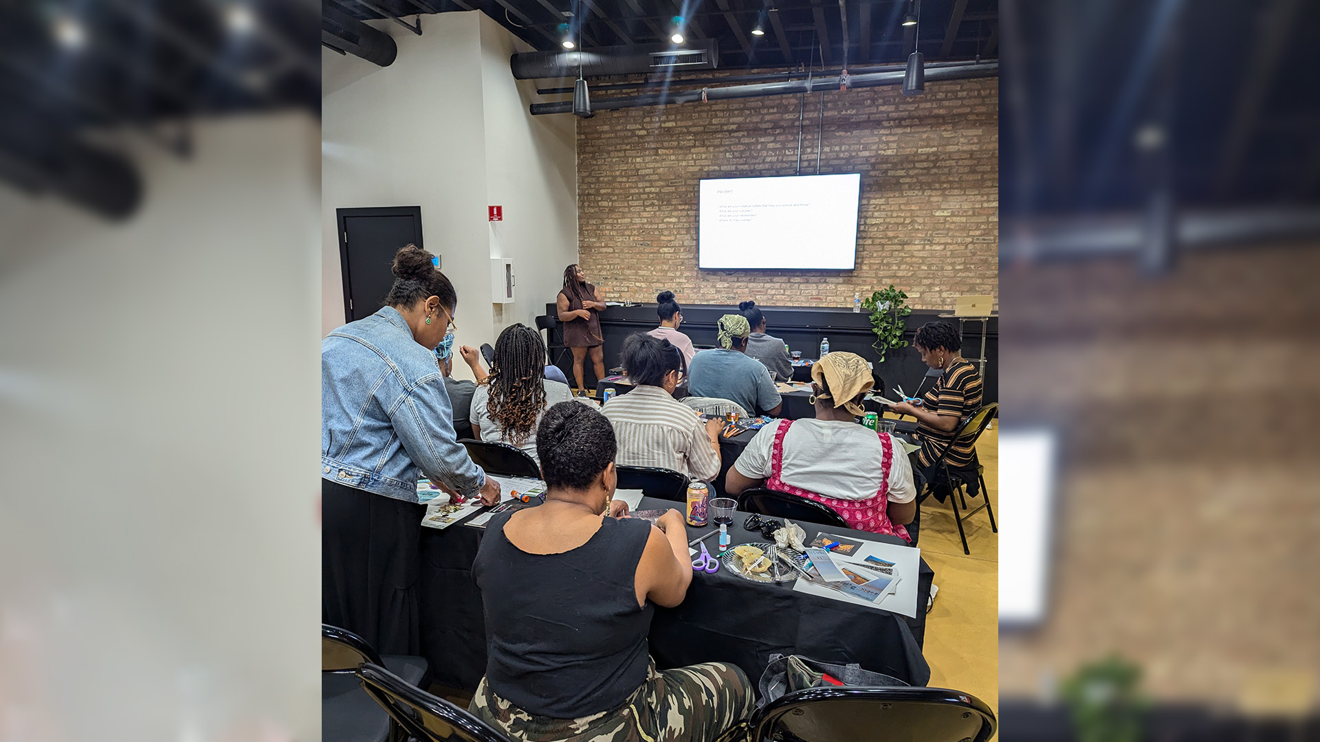 people taking a workshop in a room with tables and crafts.