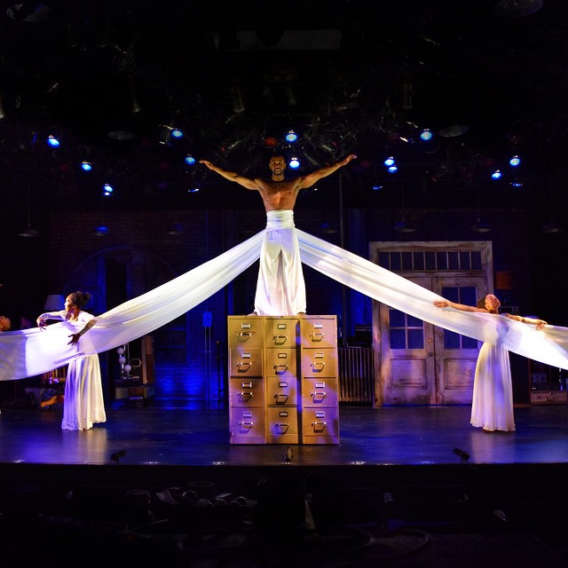 Two dancers flank C. A. as Lyons ascends.