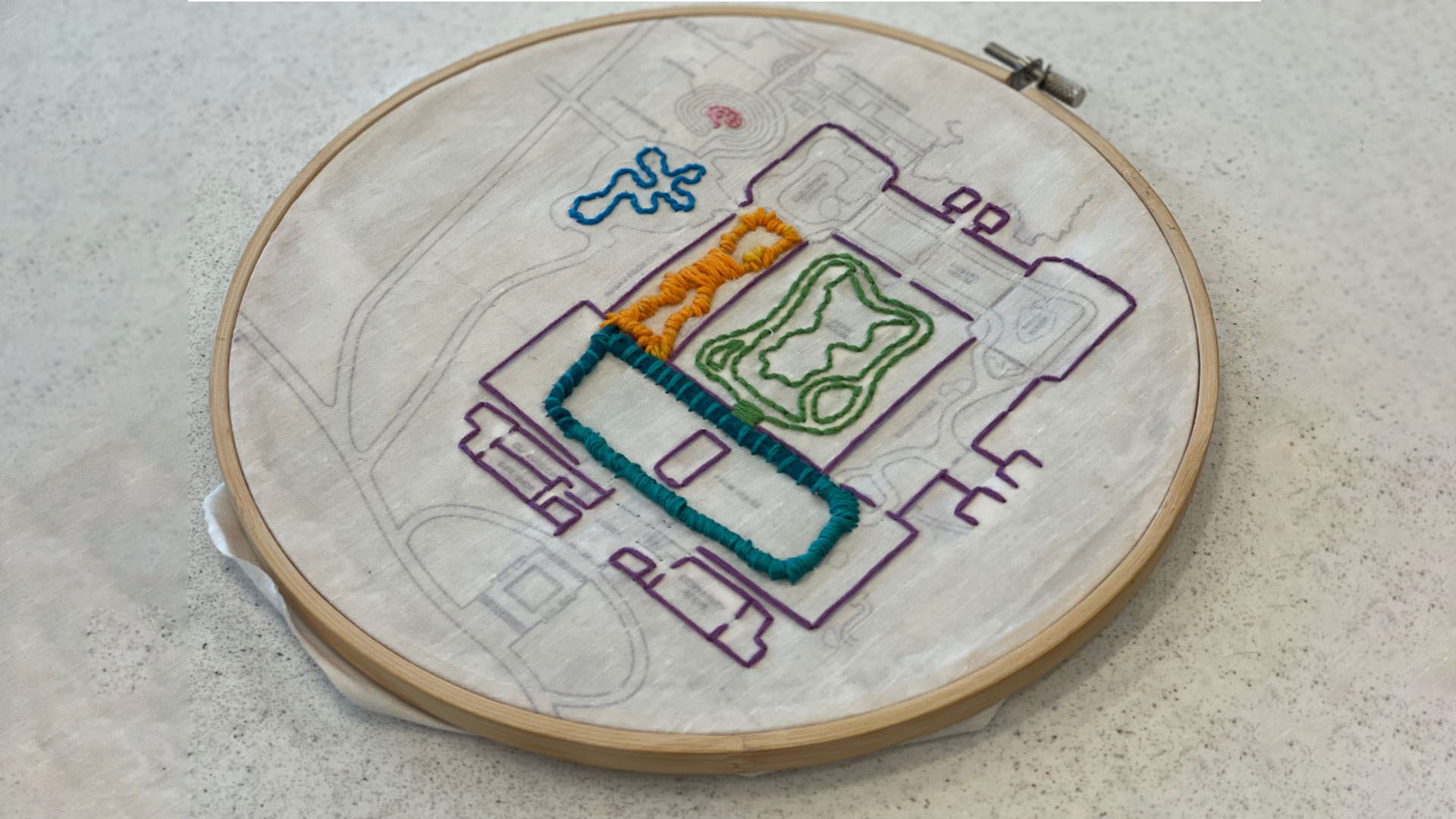 Multi-colored embroidery of a building layout.