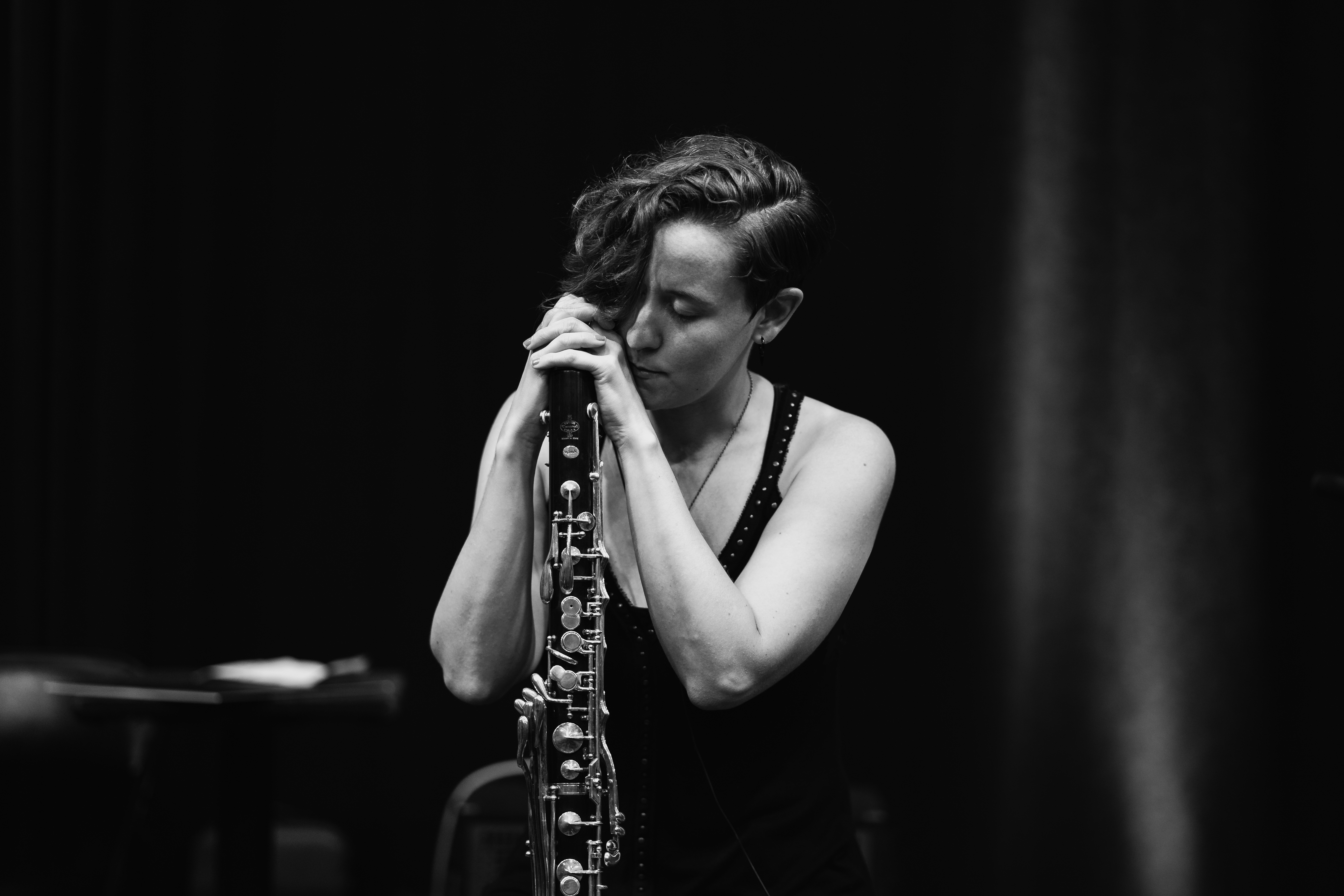 person playing base clarinet passionately on stage