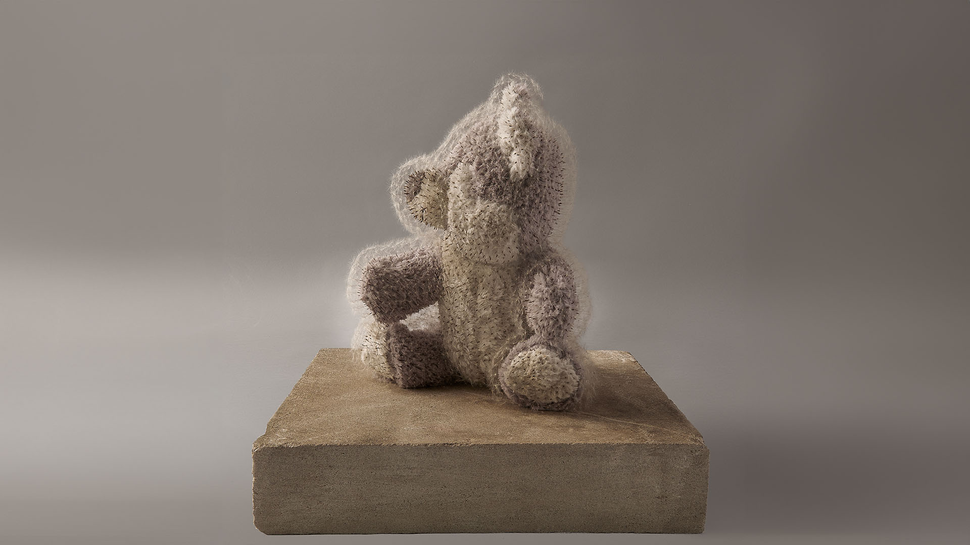 A beige teddy bear pierced with thousands of dandelion seeds, sitting on a wooden platform.