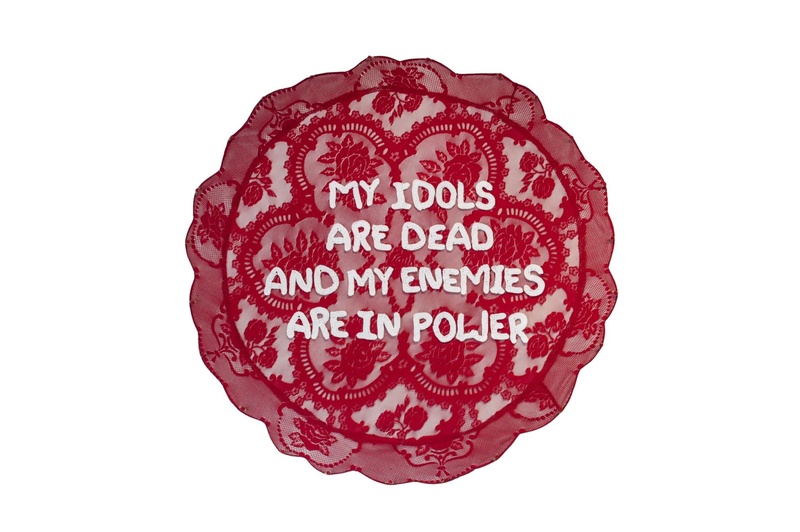  A red, circular lace backdrop with crochet text atop 