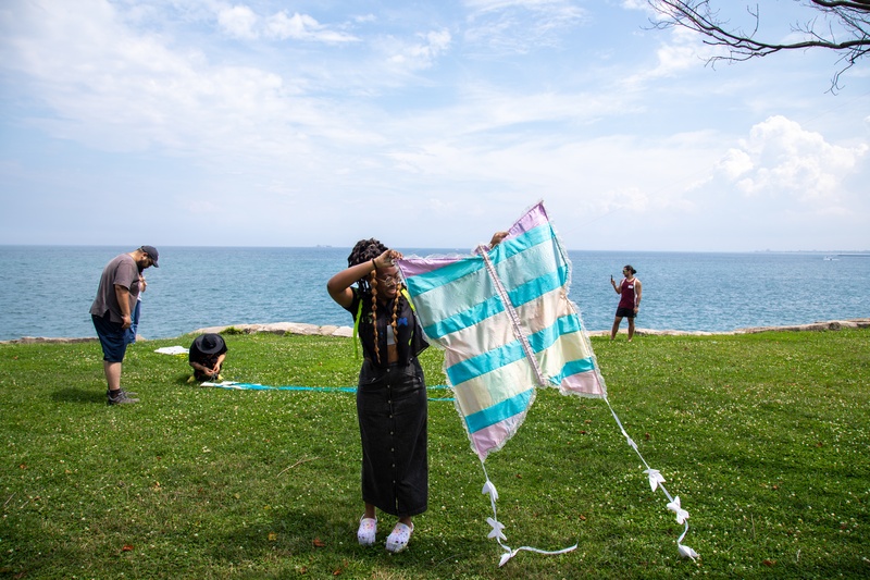  A large kite referencing the shape of a butterfly, using morei fabric to mimic stained glass in the sun. The kite has long tails with mini butterflies following 