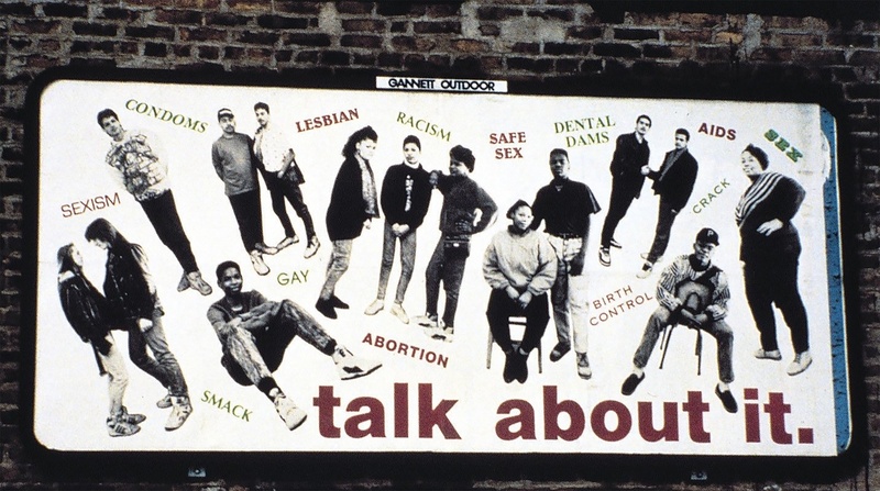  billboard with photo of teenagers, some alone, others in pairs or small groups, surrounded by words like “AIDS,” “condoms,” “racism,” and “sex.” A large caption reads: “talk about it.” 