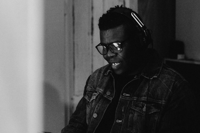  dark-skinned african american male smiling in a recording studio 