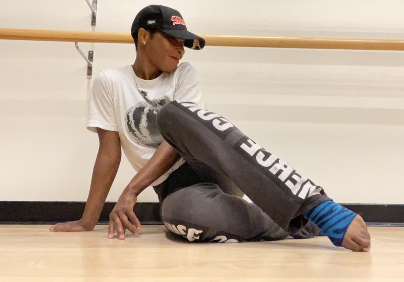  Brooks as choreographer seated on a dance floor 