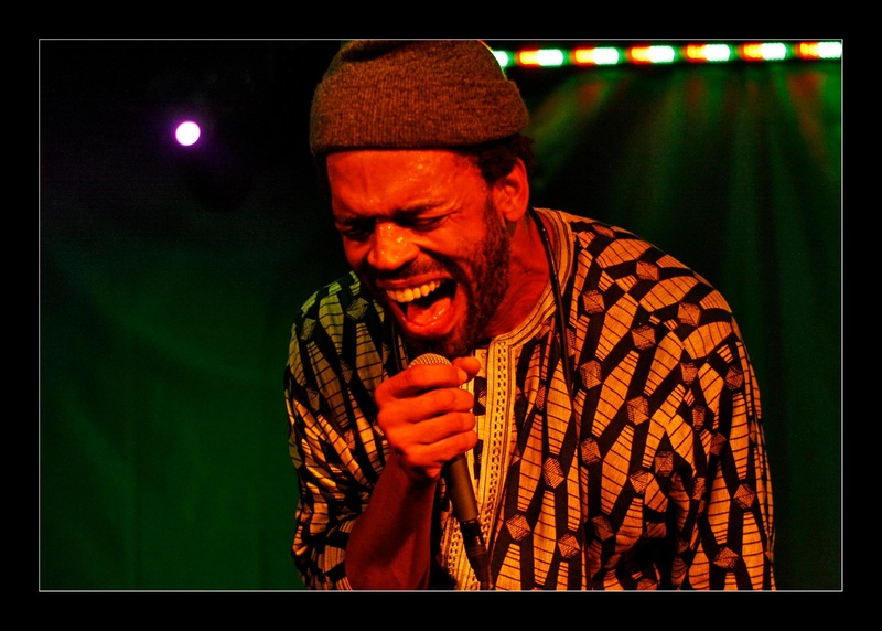  Photo of a black rapper passionately shouting into a microphone 
