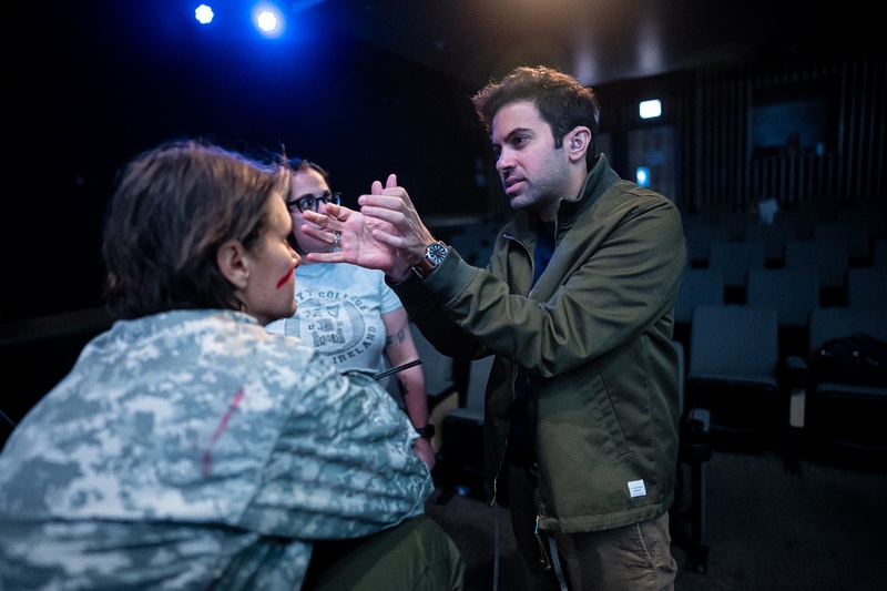  Richard, wearing a green jacket, talking to two individuals - one in an army coat, and the other in a t-shirt. 