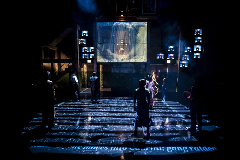  Actors standing on deck under lighting effect. 