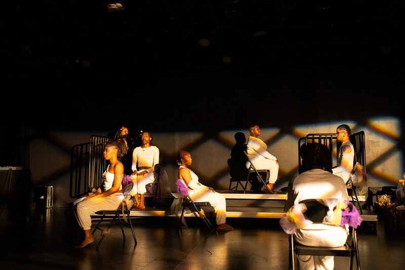  PRAISE MOTHER SQUAD performs in front of black chairs adorned with multi-colored tulle dressed in all white 