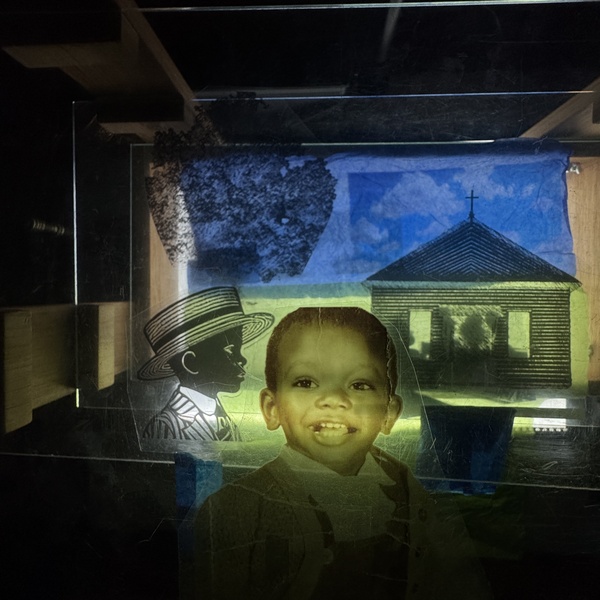  A collage of images layer on a screen. There is a small child, an illustrated child with a hate on and a drawing of a small church. 
