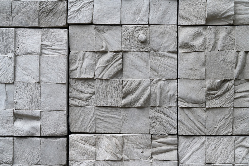  Detail image of a room installation consisting of hundreds of six-by-six inch unsealed concrete tiles cast from nearly a dozen different human cadavers. 