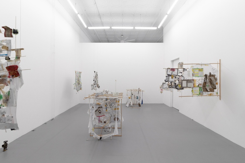  There are seven art pieces in the photo, with three on the left side of the room hanging from wires, two on the right side coming out of the wall, and two in the foreground and back of the room standing on the floor. 