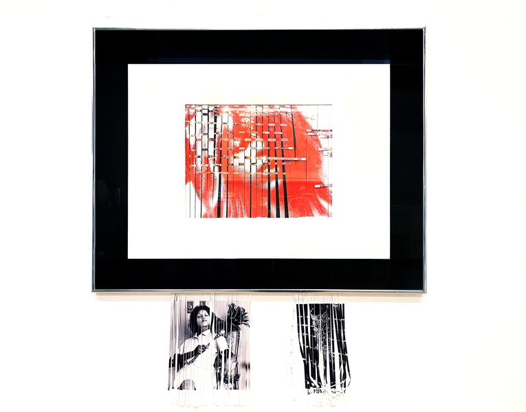  An image of person printed in red ink that has been shredded a framed in a black frame. 