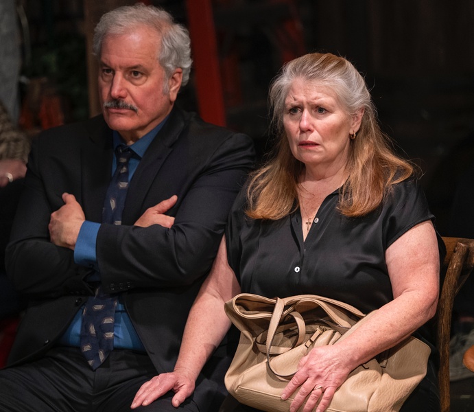  An older man and woman, dressed in black  seated 
