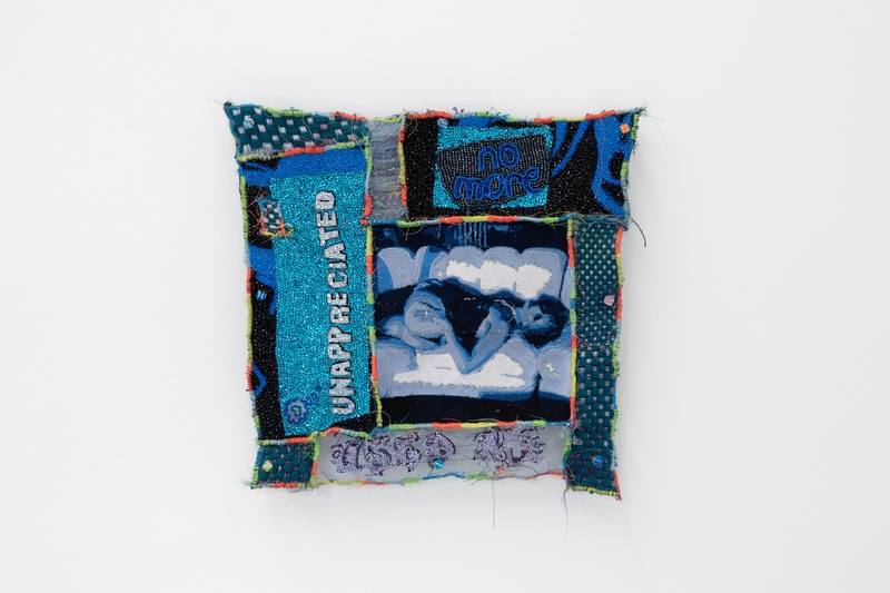  A lying embroidered figure surrounded by beaded, embroidered and rhinestoned text “no more”, “unappreciated” and “used me”. 