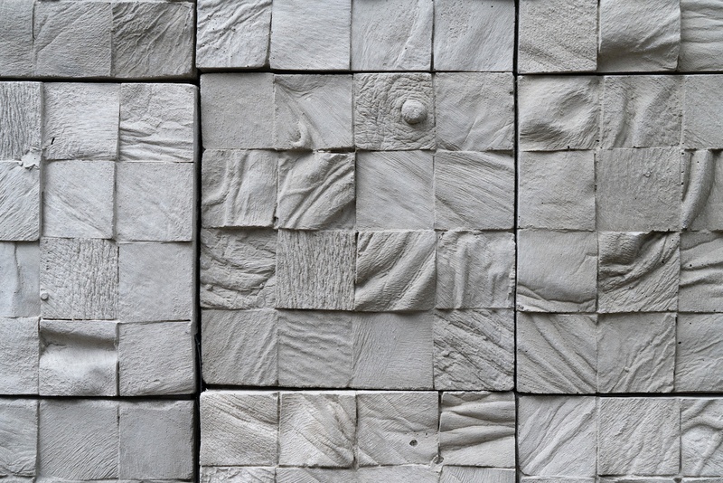  Detail image of a room installation consisting of hundreds of six-by-six inch unsealed concrete tiles cast from nearly a dozen different human cadavers. 