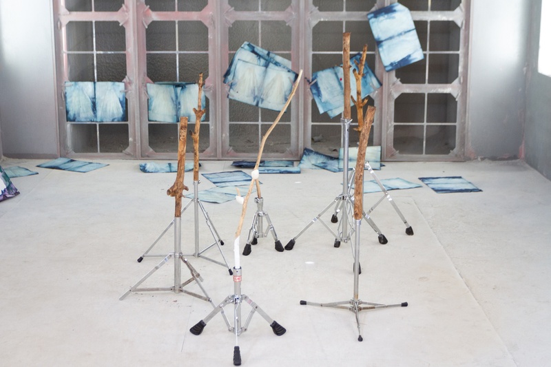  Music stands made with wood and dyed paper stand in a white room. 
