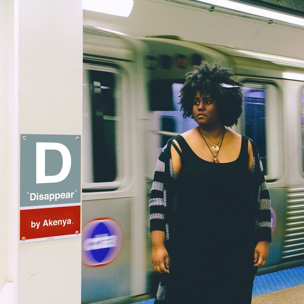  Black woman with curly hair stands in front of a subway train speeding behind her in a blur, with a mock CTA station identifier on a column near her that reads "Disappear" 
