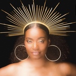 Beautiful, brown skinned, voluptuous woman with natural hair in a gold crown and against a black background.