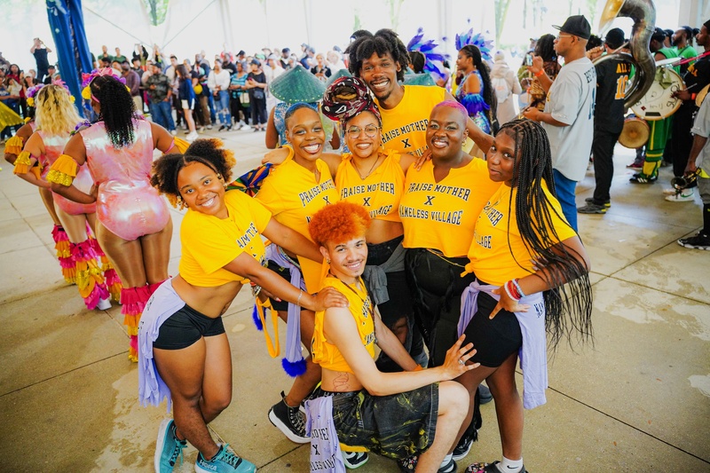  PRAISE MOTHER SQUAD in bright yellow shirts huddled together and smiling 