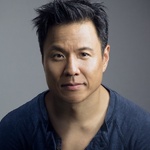 Asian American man with short hair and wearing dark blue shirt