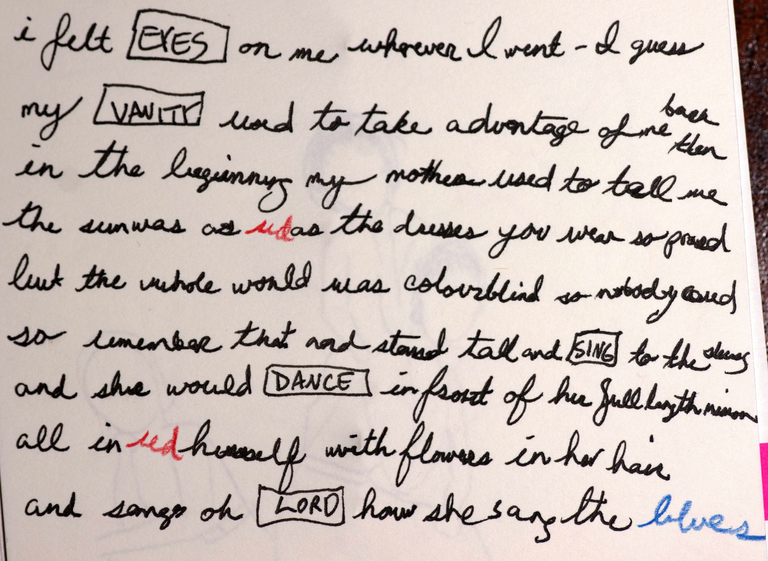 A photo of a visual poem, Sleepwalk, which is written in cursive on cream colored art paper, in black ink with the words red and blue written in those colors in colored pencil. Text reads: I felt eyes on me wherever I went - I guess my vanity used to take advantage of me back then in the beginning, my mother used to tell me the sun was as red as the dresses you wear so proud
but the whole world was colourblind so nobody cared so remember that and stand tall and sing to the skies and she would dance in front of her full-length mirror all in red herself with flowers in her hair and sang oh lord how she sang the blues.