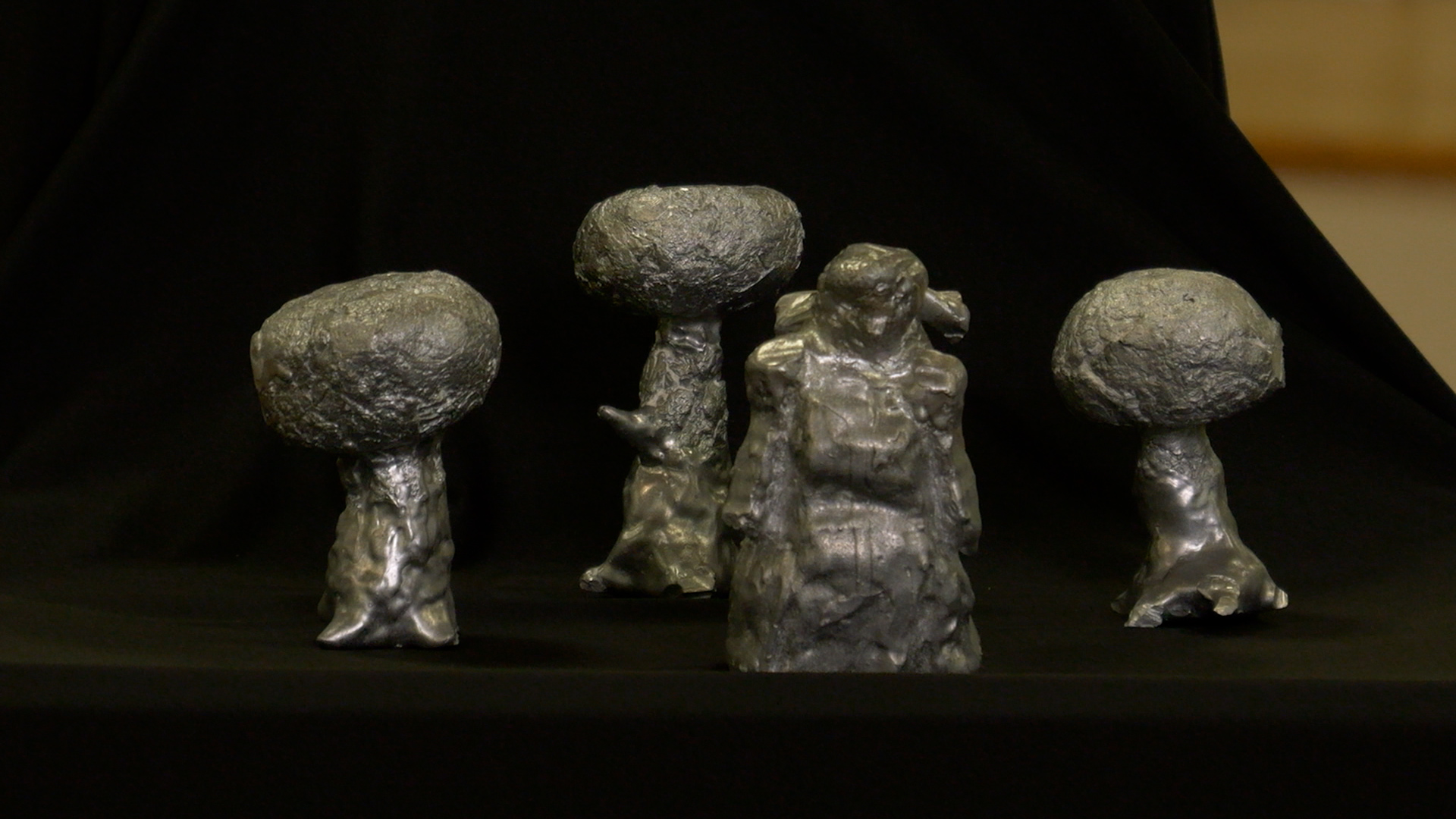 aluminum sculptures of trees and a figure